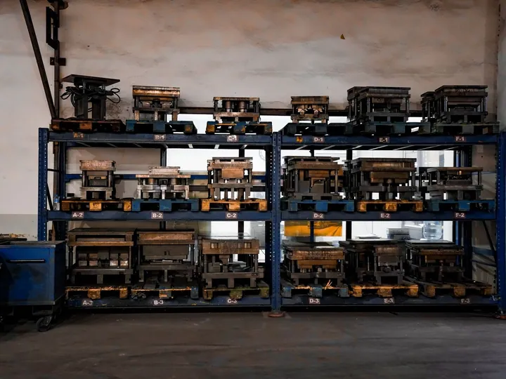 Metal molds stored on industrial shelves